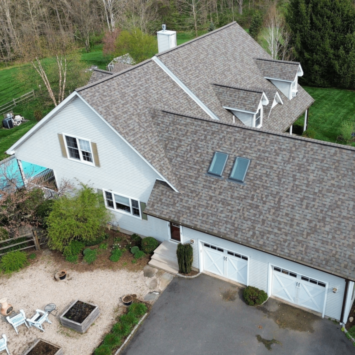Angled drone view of a completed roof replacement on a white Connecticut home.