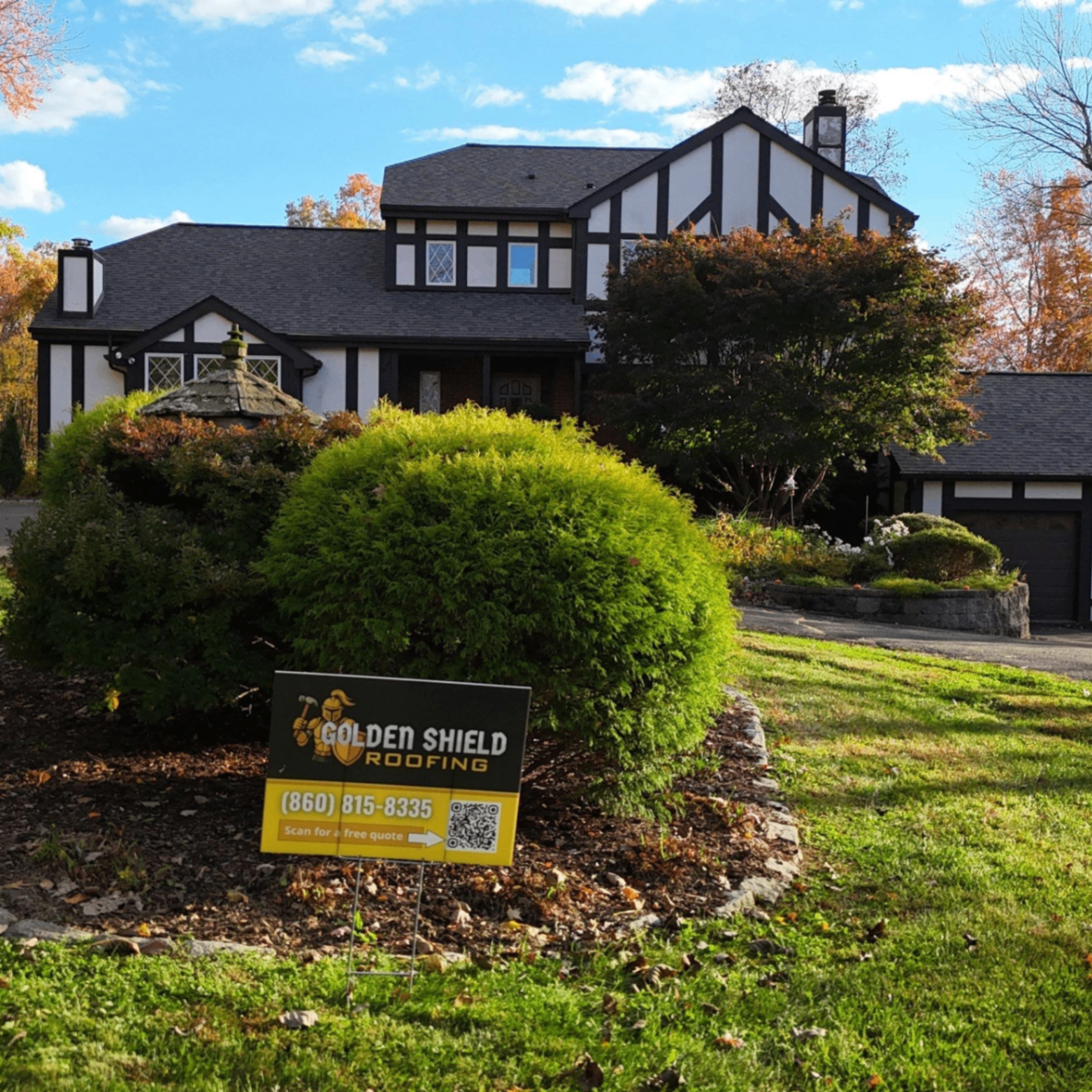 Completed roofing project on a Tudor-style Connecticut home with a Golden Shield yard sign.